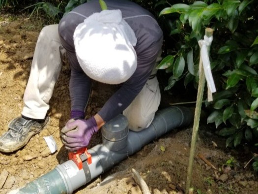 浄化槽汚水管の修繕工事をする株式会社ケイエム設備の作業スタッフ